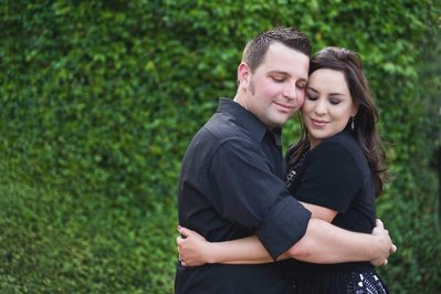 Couple in front of green bush. Engagement photos Atlanta.