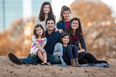 Family posing for photo shoot in Piedmont Park with Photographer.