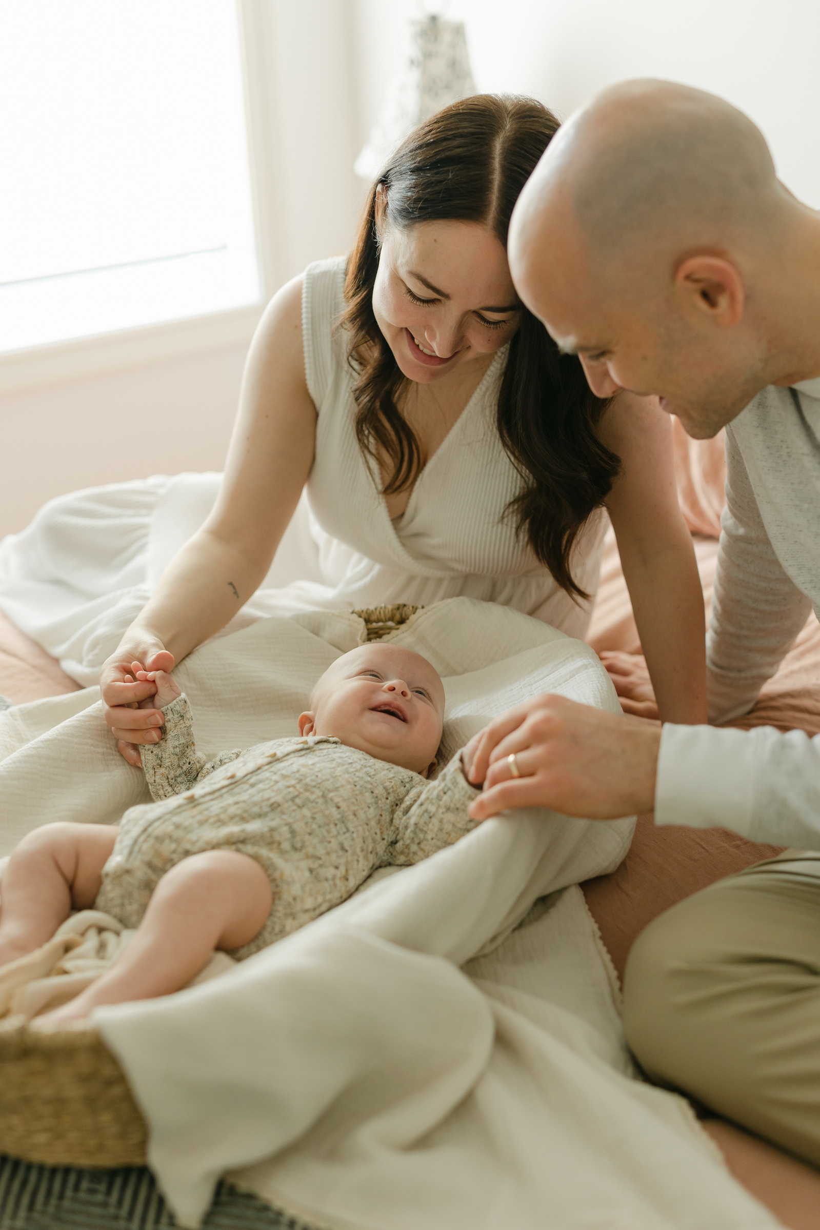Mother and father smiling at their newborn baby