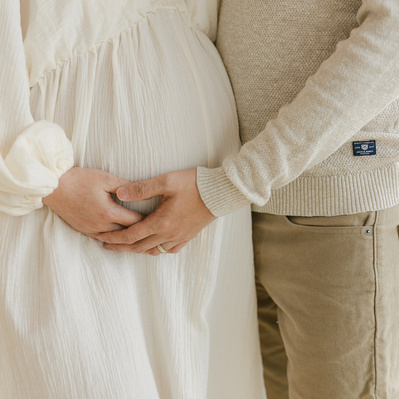 Pregnant woman and her husband holding her pregnant belly