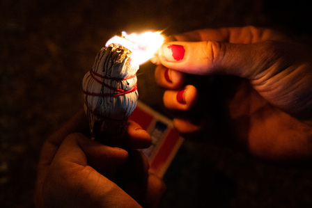 A protester lights a bundle of white sage — a sacred herb in many Native American cultures — in front of the Los Angeles County sheriff's station in South Los Angeles, Monday, Sept. 7, 2020.
