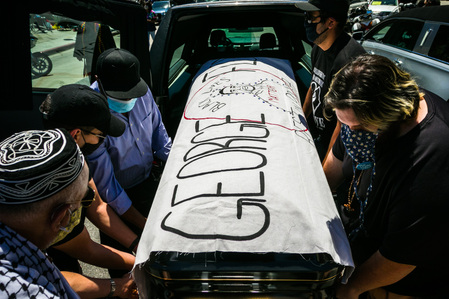 Pallbearers carry one of four empty caskets from a hearse during a memorial procession for victims of police violence, held in solidarity with the public viewing for George Floyd in Houston, Floyd's hometown, Monday, June 8, 2020.