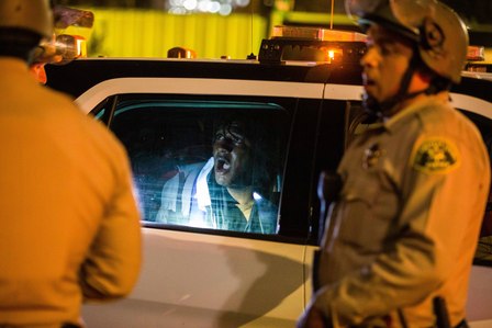​A protester that Los Angeles County sheriff's deputies restrained for asking to keep his confiscated phone shouts in pain from inside a police vehicle.
