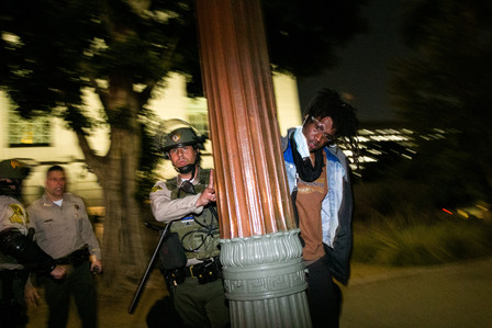 ​A Los Angeles County sheriff's deputy shoves a protester against a street light in front of the LA City Hall Wednesday, June 3, 2020.