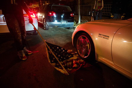 Protesters in Hollywood drive over an upside-down American flag before marching to a Los Angeles sheriff's station in West Hollywood, Friday, Sept. 25, 2020.
