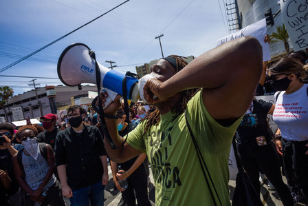A protest leader chants with the crowd in front of the Beverly Center in Los Angeles after marching peacefully from Pan Pacific Park. Black Lives Matter-Los Angeles, which organized the demonstration called for discipline at the beginning of the march.
