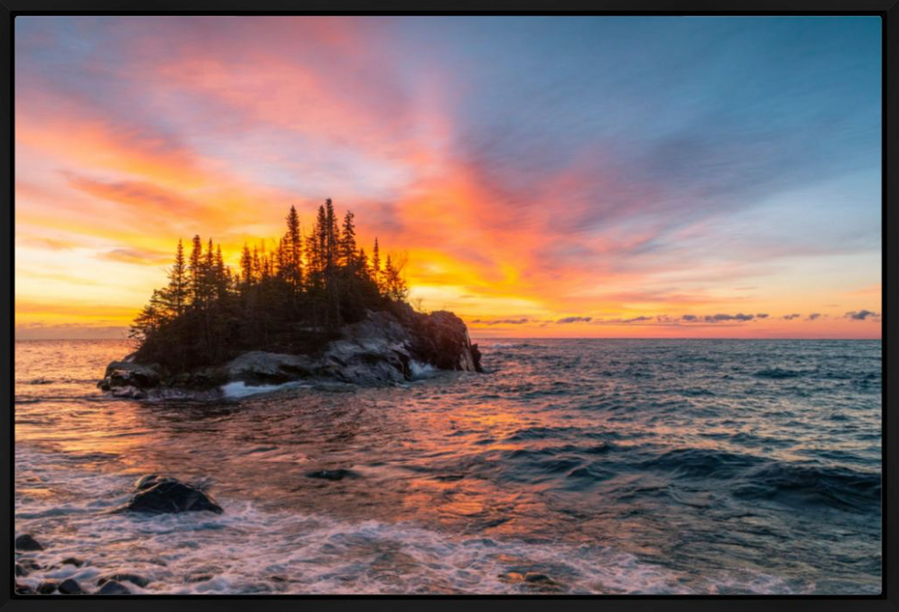 Vibrant color clouds at sunrise above Lake Superior and an island in Northern Minnesota