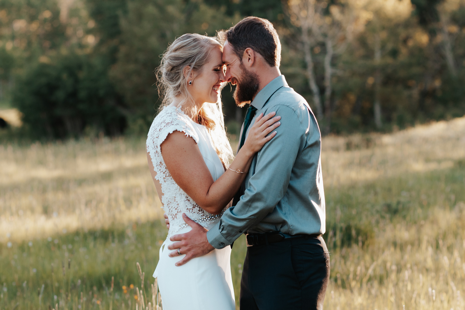Bride and groom hugging face to face in a field in Colorado during a Denver Wedding. 