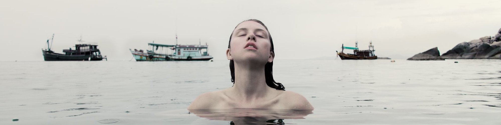 self portrait in thailand in ocean with boats