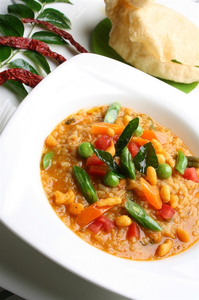 Bowl of Bisibele Baath and papads in a food photography session in Bangalore