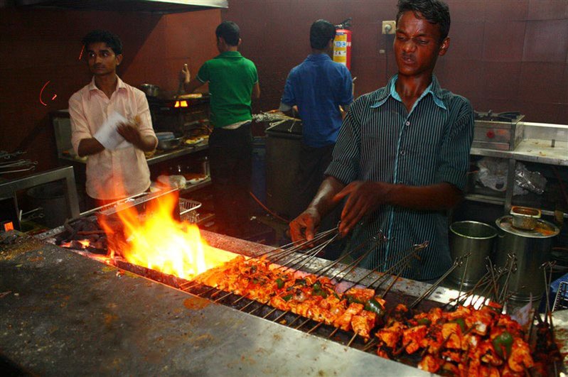 Kitchen staff preparing rolls over an open grill at Ayub's Rolls, Kala Ghoda, Mumbai
