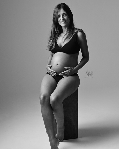 Mujer embarazada sentada fotografía profesional blanco y negro