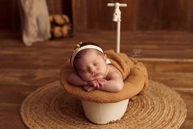 Bebe tumbado sobre un bañerita  vintage. fotografía profesional