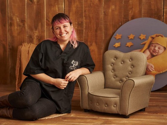 Fotografa Gala Pillado posando en su estudio de Gijón junto a un mini sillón para bebes