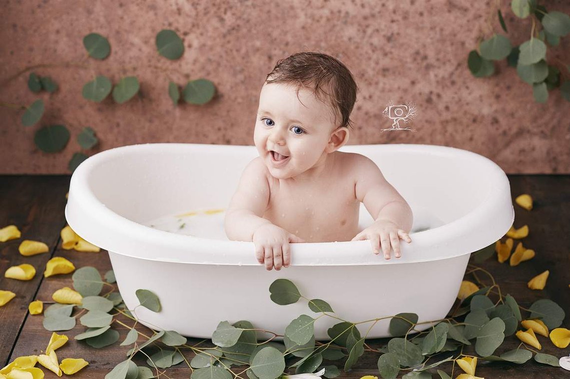 Bebe riendo en bañera con leche