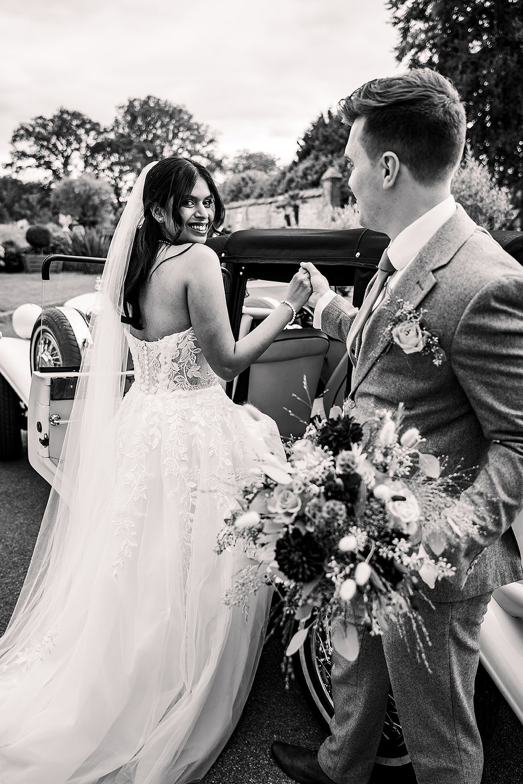 Guildford Manor Hotel & Spa Wedding Groom Helping Bride into Vintage Car
