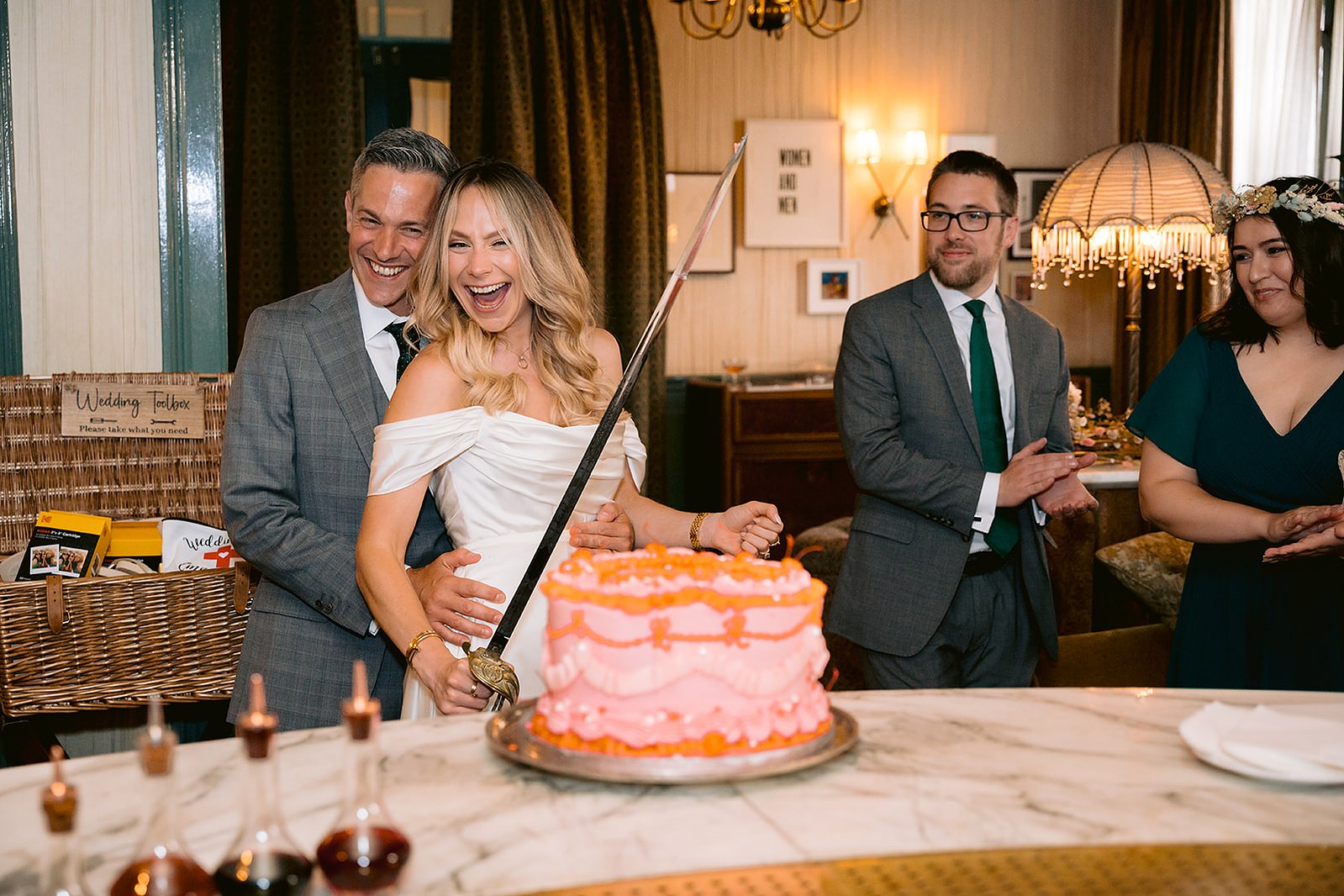 The Old Marylebone Town Hall Wedding Ruth Buscombe and Nathan Divey Cutting Cake with Sword at Kettners