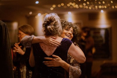 A candid moment during a fun ceilidh dance at a London wedding, captured by a South London wedding photographer with a natural, genuine, and cinematic style. Guests laugh and connect under warm lights in a relaxed and unposed atmosphere.