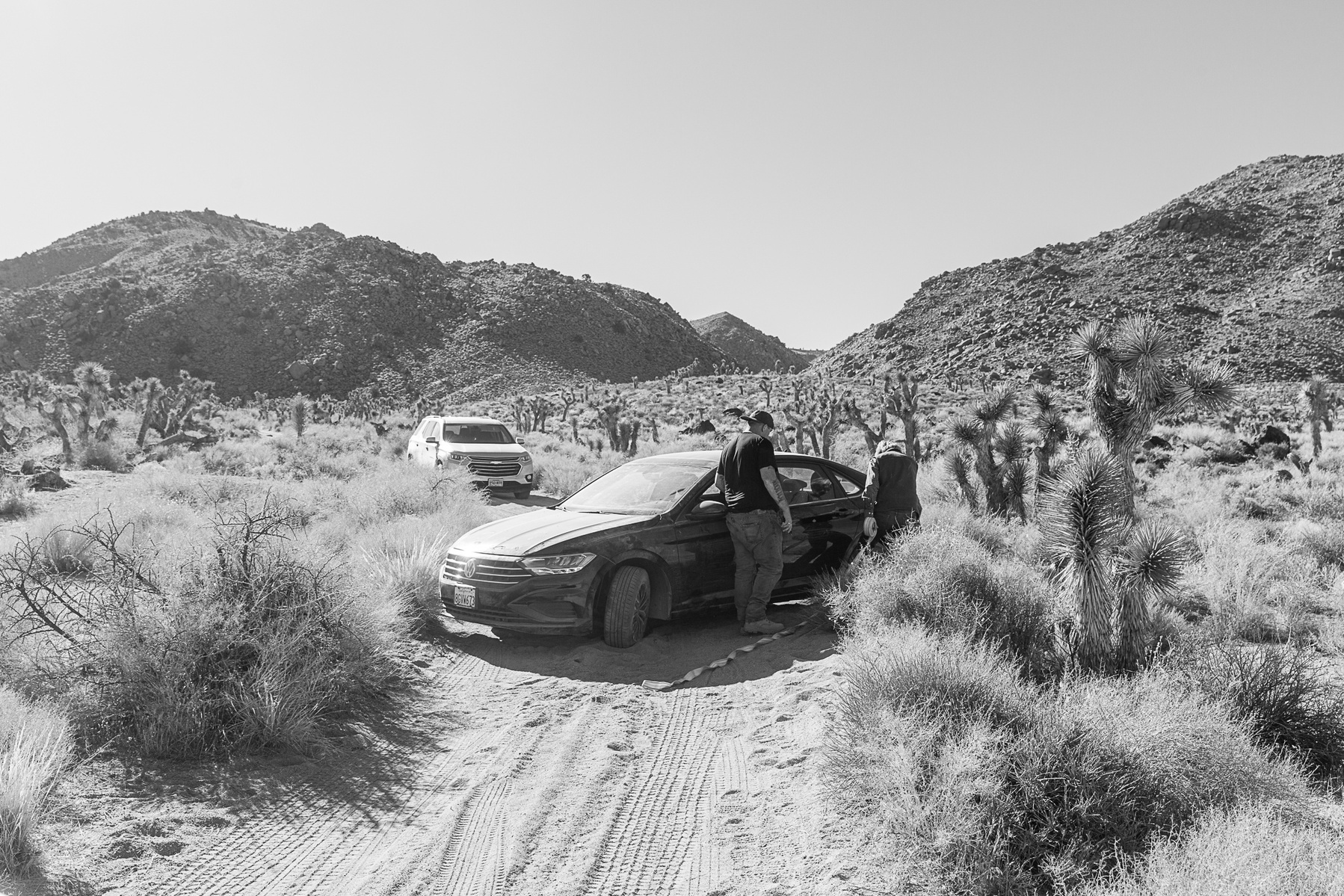 two men pulling a car out of the ditch