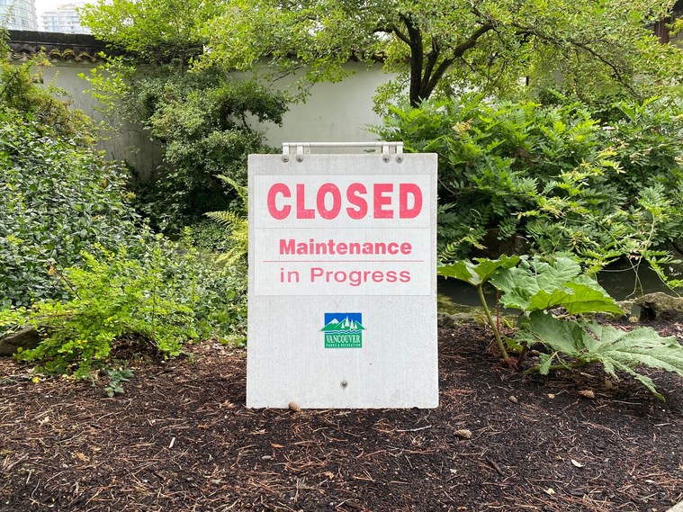 A sign in the middle of a garden reading 