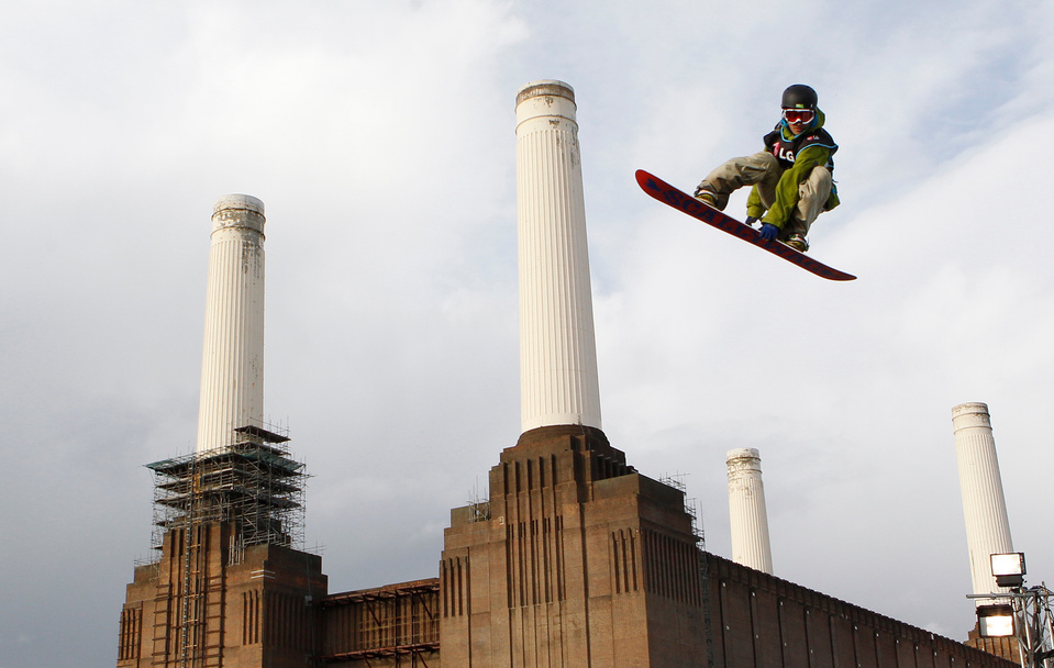 a man snowboarding with a backdrop of battersea power station