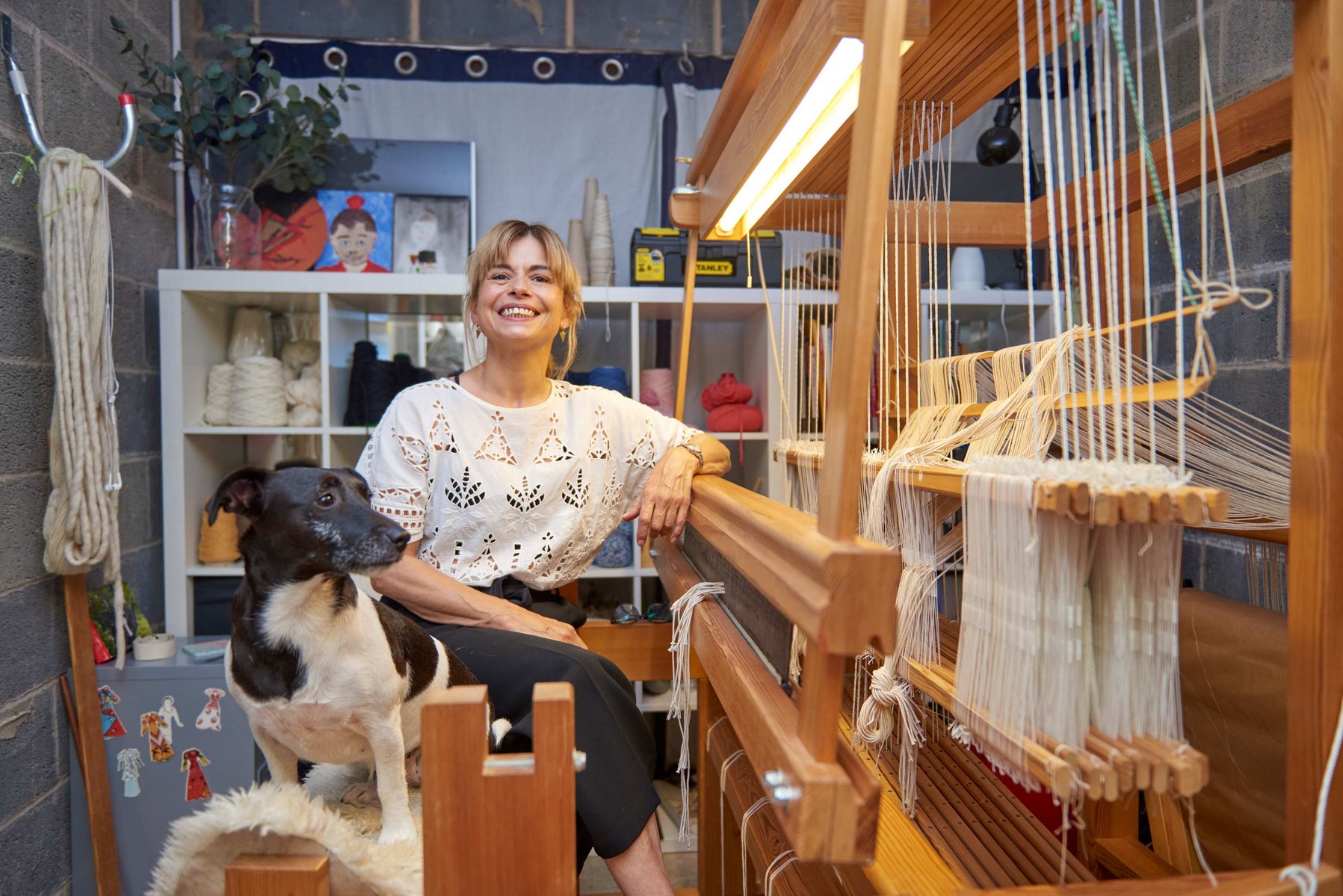 Woman smiling with dog with a loom.