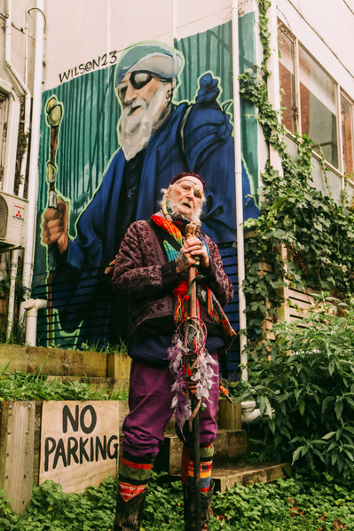 Desi – also known as the Wizard of Belgrave – poses in front of a mural of himself painted by James Wilson. 