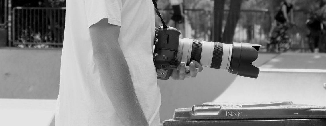 A man holding a camera by their waist.