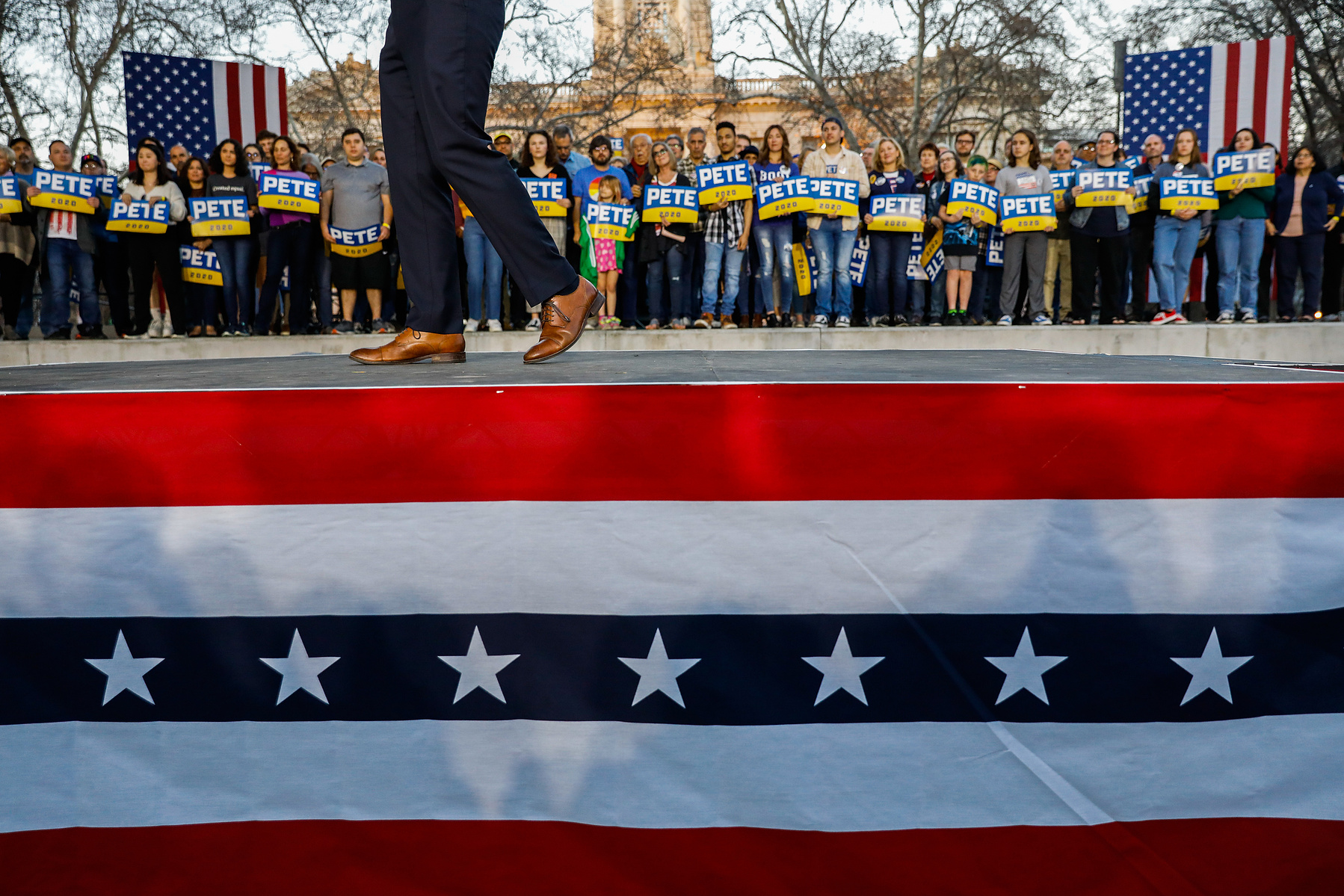 Supporters look on as Democratic presidential candidate and former South Bend, Indiana Mayor Pete Buttigieg speaks at a campaign rally at Cesar Chavez Plaza in Sacramento, California on Friday, Feb. 14, 2020.