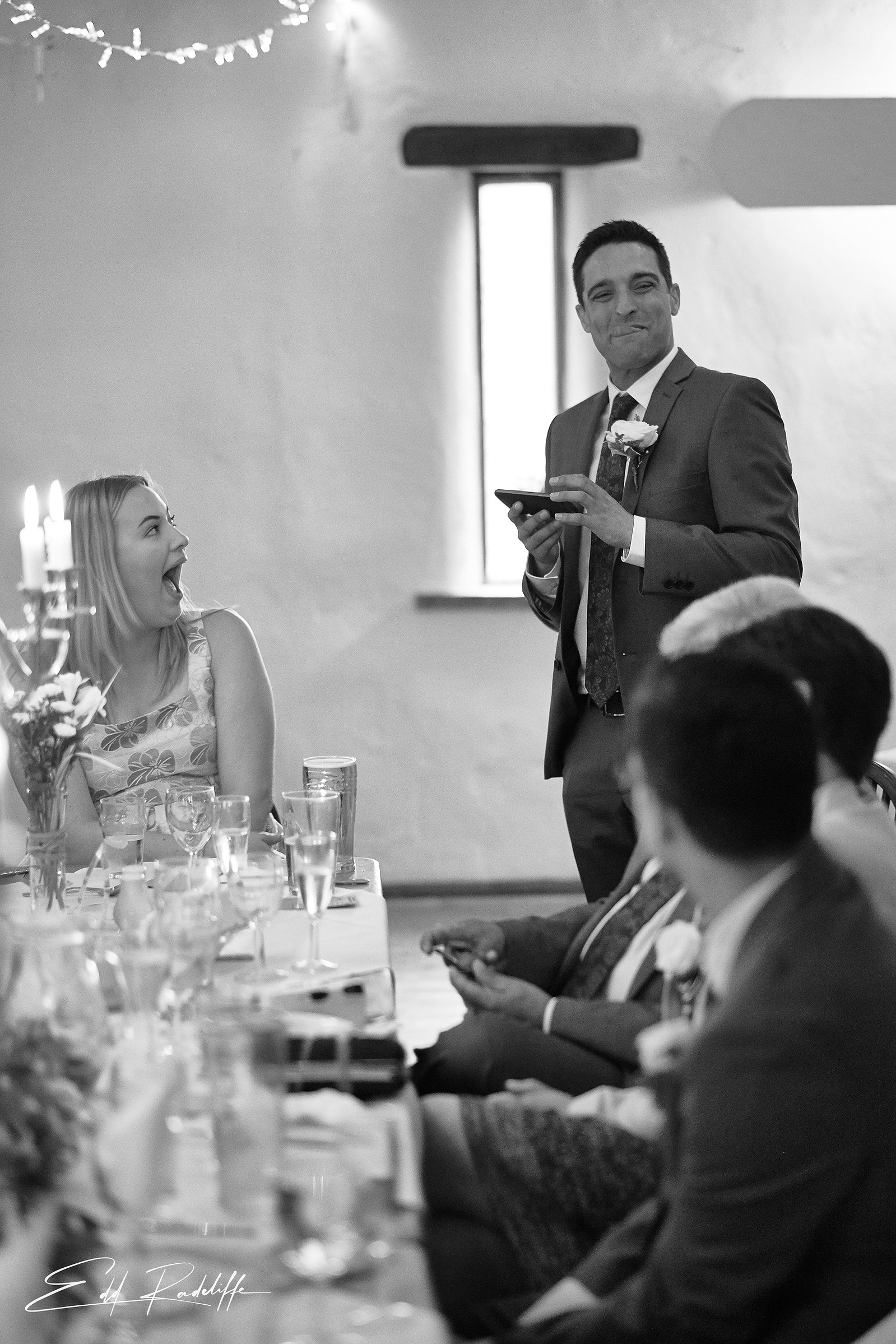 Best man gives speech while wedding guest looks on laughing at the Square and Compass in Somerset for Edd Radcliffe Photography - documentary style wedding photography