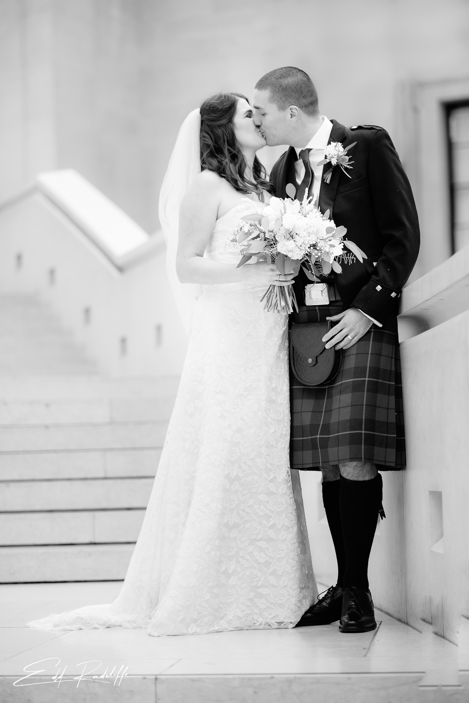 Bride and Groom share a kiss standing on the steps outside Islington Town Hall for Edd Radcliffe Photography - documentary style wedding
