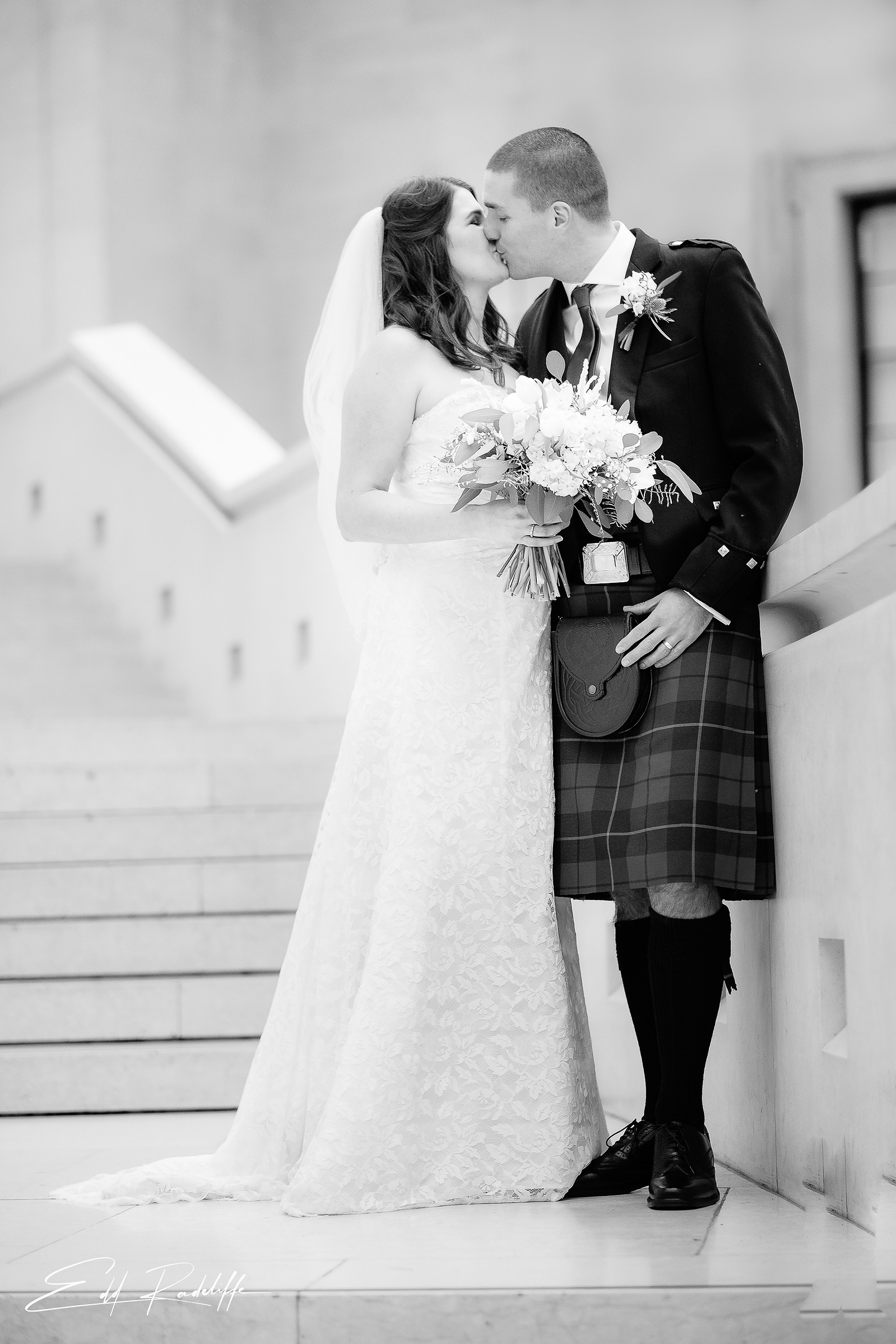 Bride and Groom share a kiss standing on the steps outside Islington Town Hall for Edd Radcliffe Photography - documentary style wedding