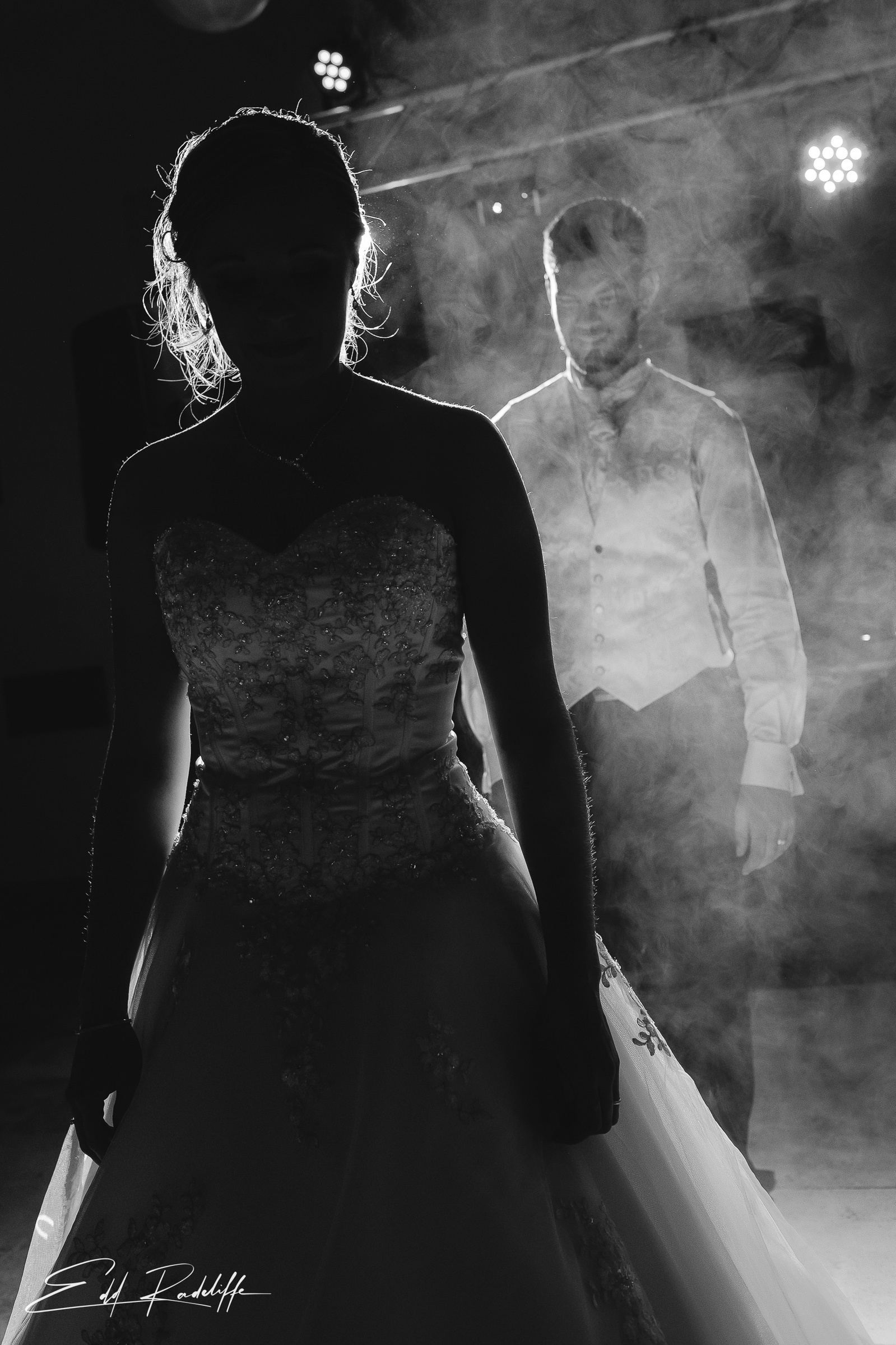 Groom stands behind Bride surrounded by smoke on the dancefloor waiting to start their first dance at Garons, France for Edd Radcliffe Photography - documentary style wedding photography