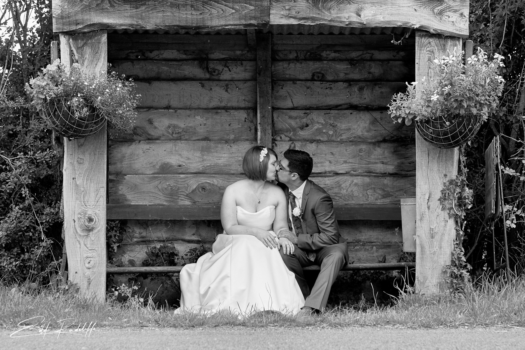 Bride and Groom kiss in old fashioned bus stop in countryside - documentary wedding photography - Somerset wedding photography for Edd Radcliffe Photography