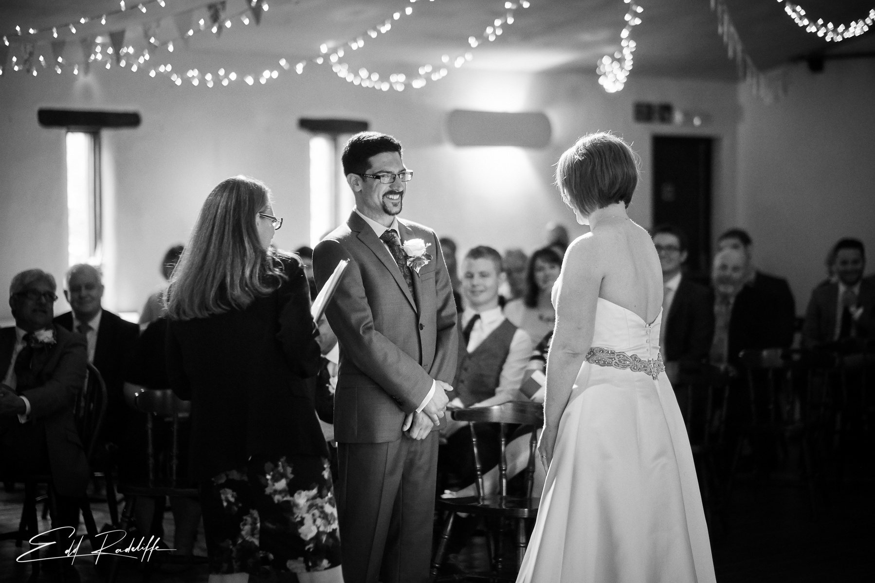 Beaming Groom and Bride saying their vows in front of the congregation at the Square and Compass in Somerset for Edd Radcliffe Photography - documentary style wedding photography