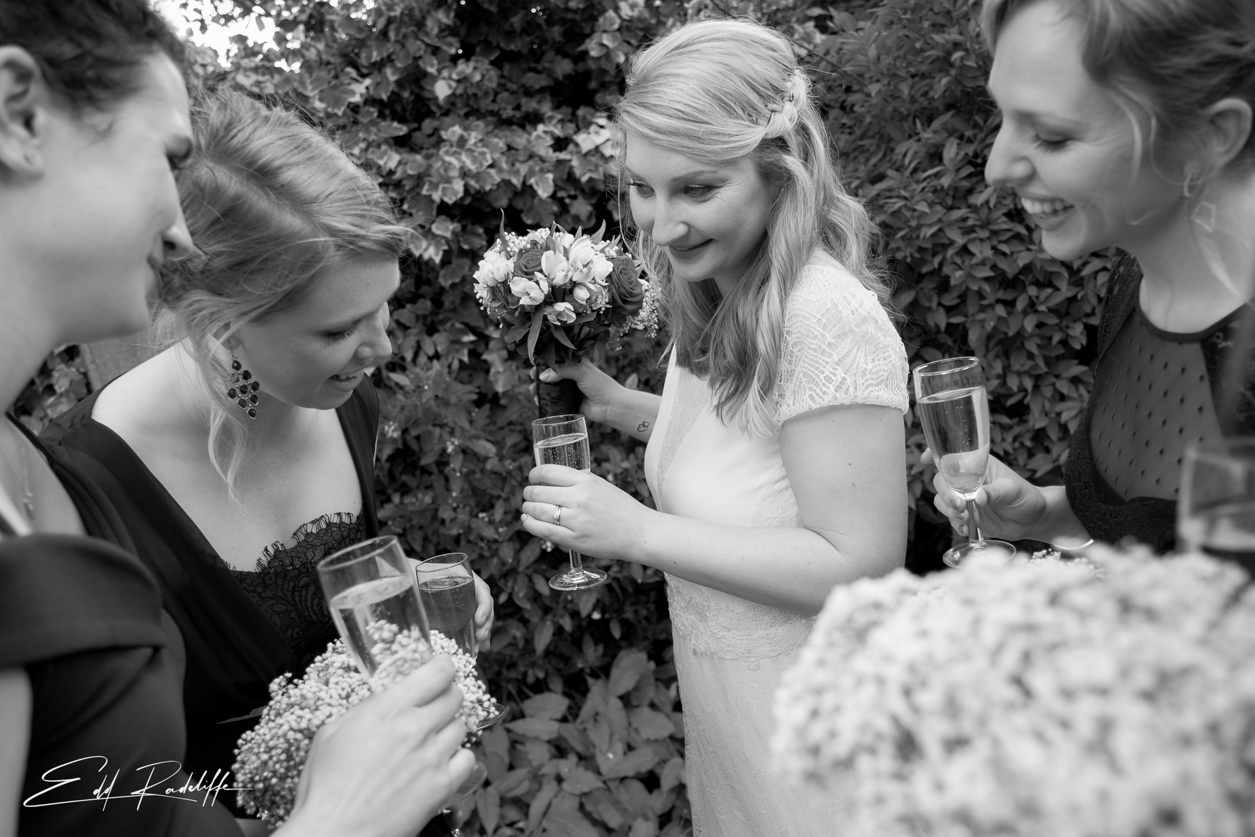Bridesmaid looks at Brides wedding ring while they hold champagne glasses at the Reid Rooms, Chelmsford for Edd Radcliffe Photography - documentary style wedding photography