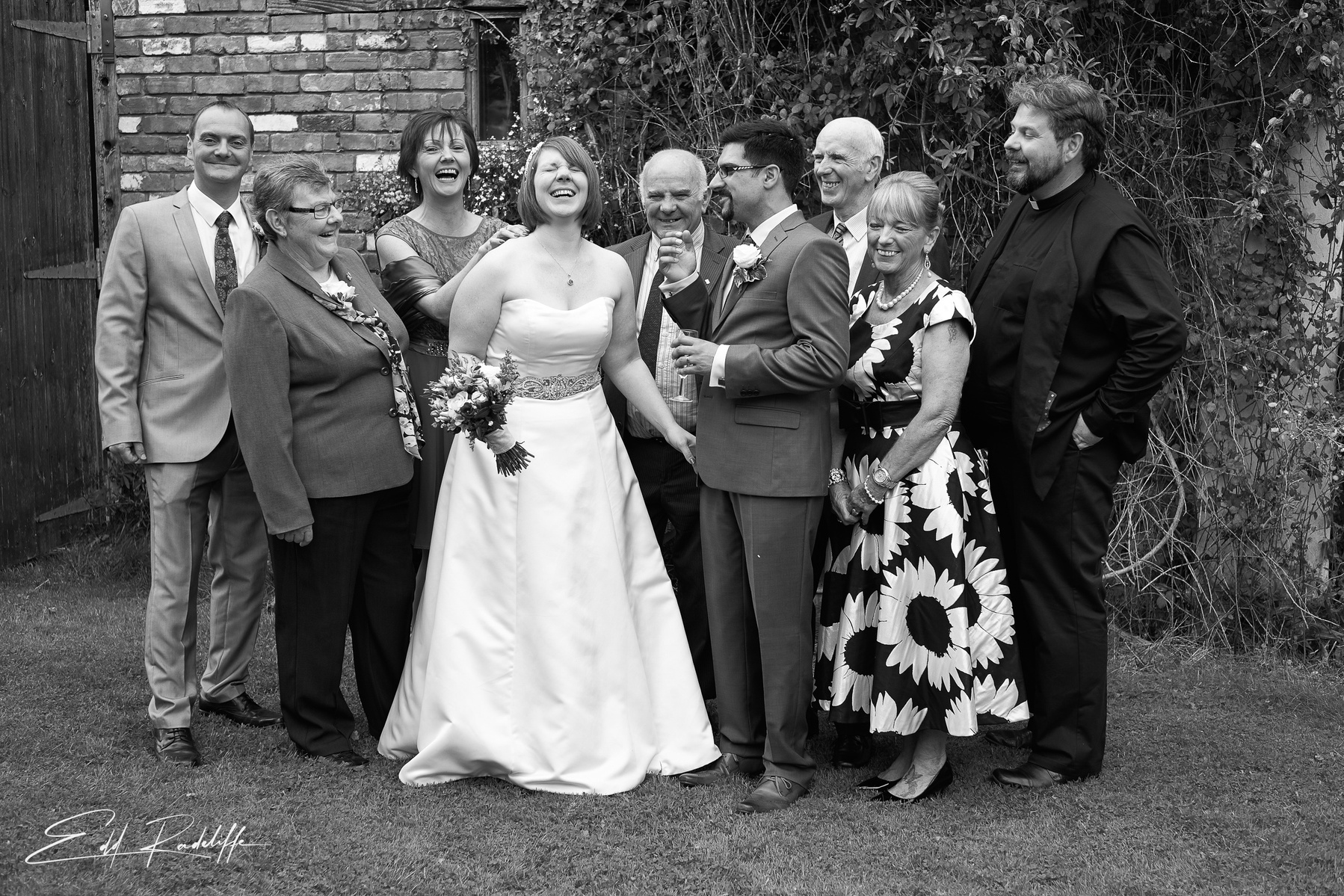 Bride laughs surrounded by happy friends and family at the Square and Compass in Somerset for Edd Radcliffe Photography - documentary style wedding photography