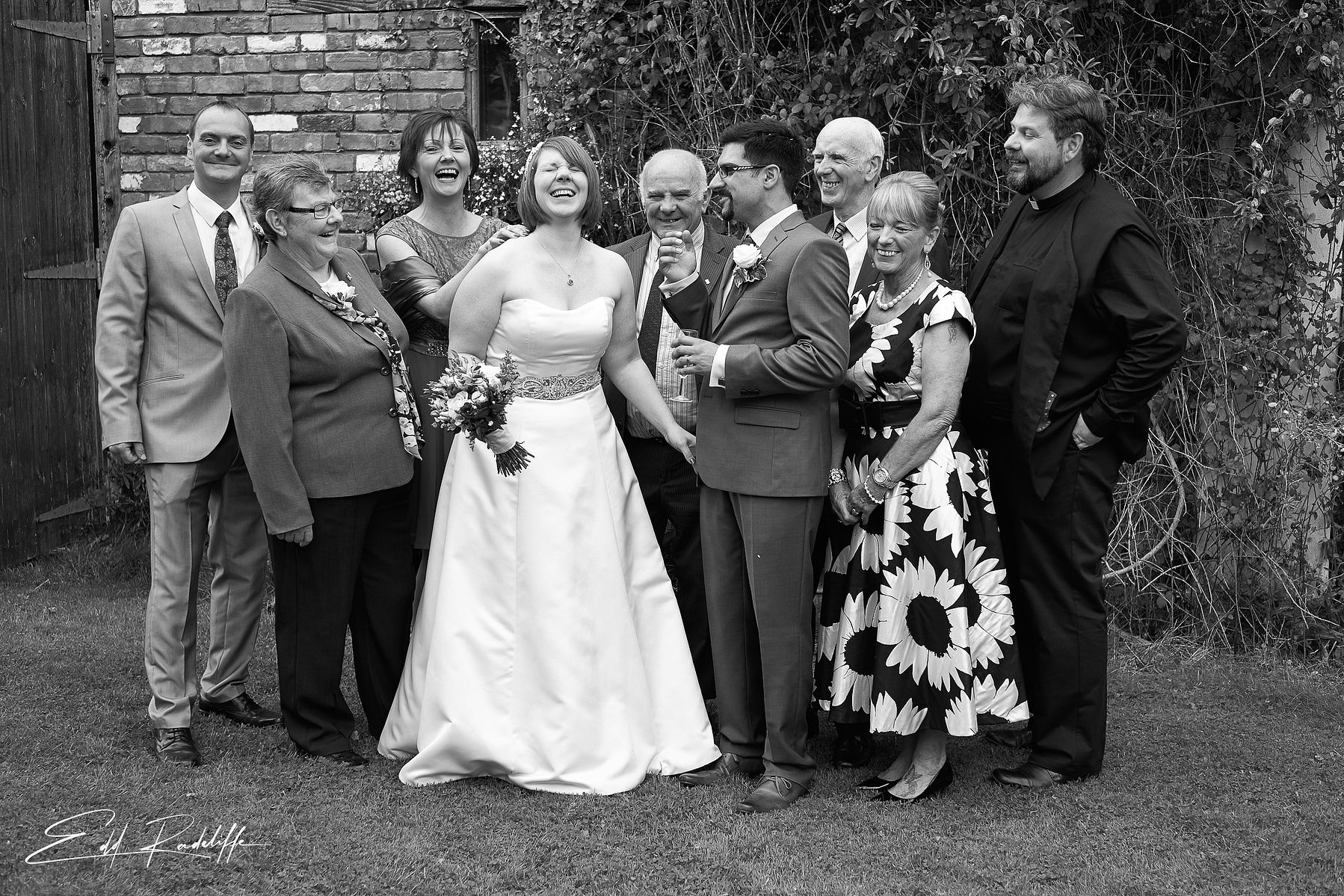 Bride laughs surrounded by happy friends and family at the Square and Compass in Somerset for Edd Radcliffe Photography - documentary style wedding photography
