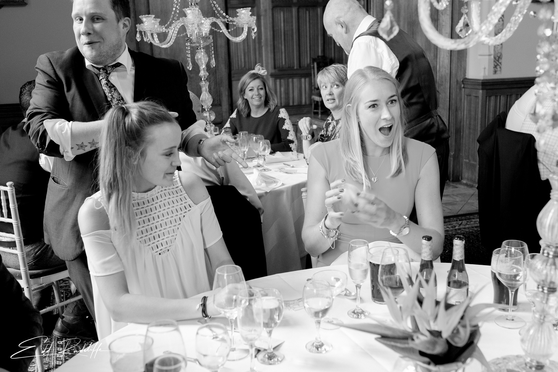 Wedding guests laugh while sitting at reception at Carlton Towers, Yorkshire for Edd Radcliffe Photography - documentary style wedding photography