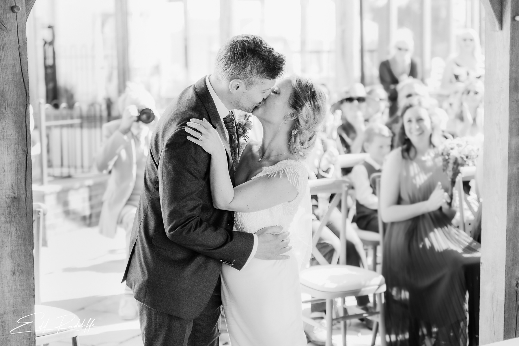 Bride and Groom share a happy kiss after wedding ceremony at Groomes in Hampshire for Edd Radcliffe Photography - documentary style wedding photography