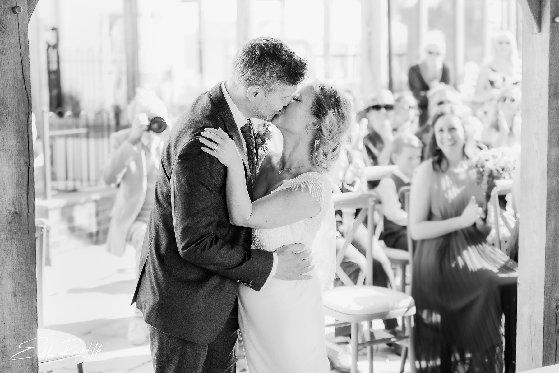 Bride and Groom share a happy kiss after wedding ceremony at Groomes in Hampshire for Edd Radcliffe Photography - documentary style wedding photography
