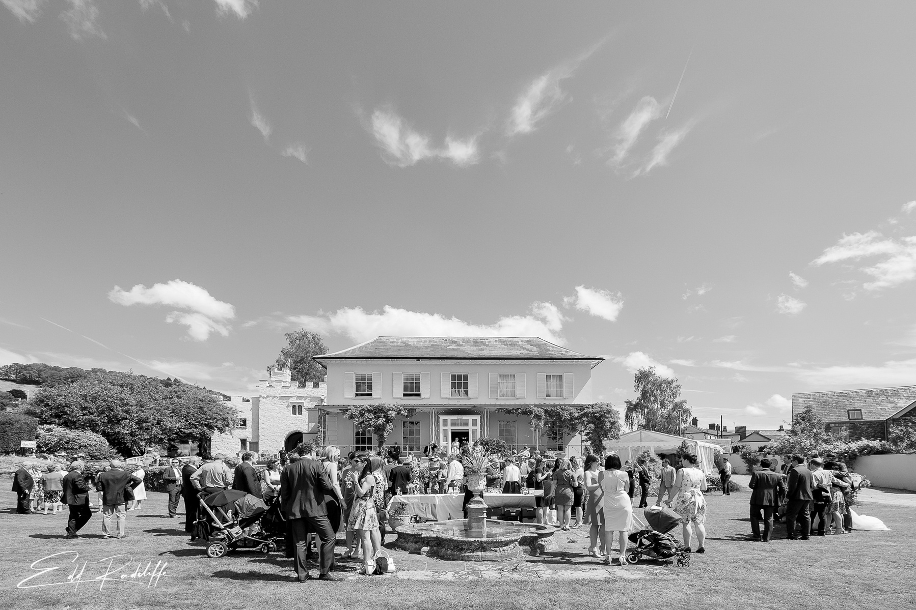 View of wedding guests mingling in front of Porthmawr Country House in Crickhowell, Wales for Edd Radcliffe Photography - documentary style wedding photography