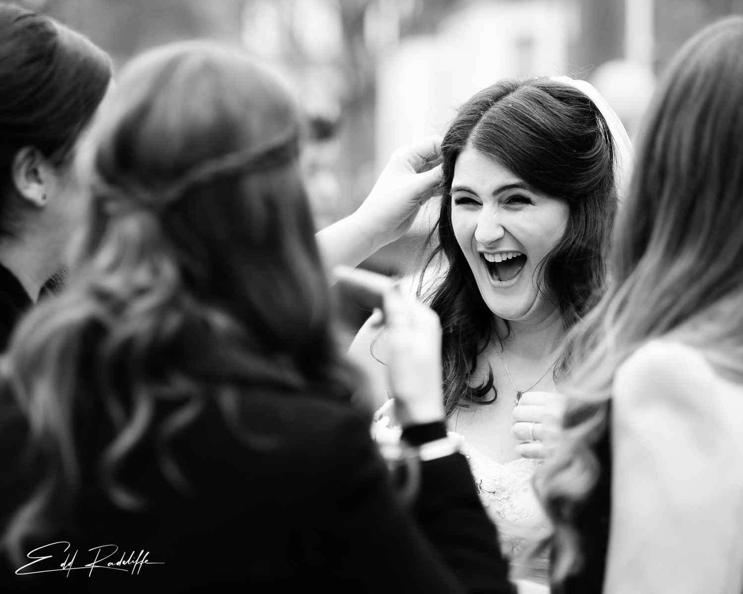 Bride laughs while surrounded by wedding guests at Chiswell Street Dining Rooms, Islington for Edd Radcliffe Photography - documentary style wedding photography