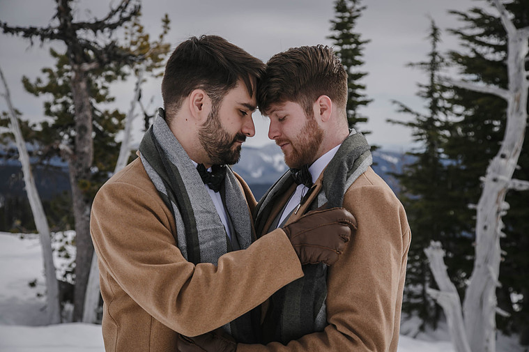 Same sex couple hug before eloping on Mt Hood in Oregon.