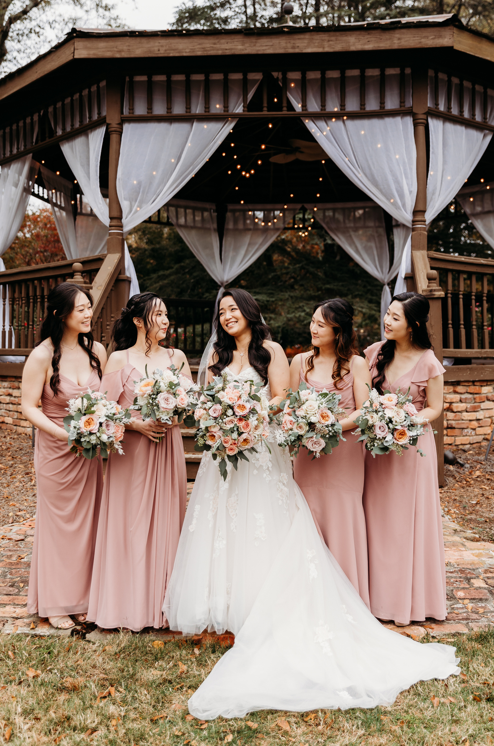 bridesmaids dressed in light pink surrounding the bride