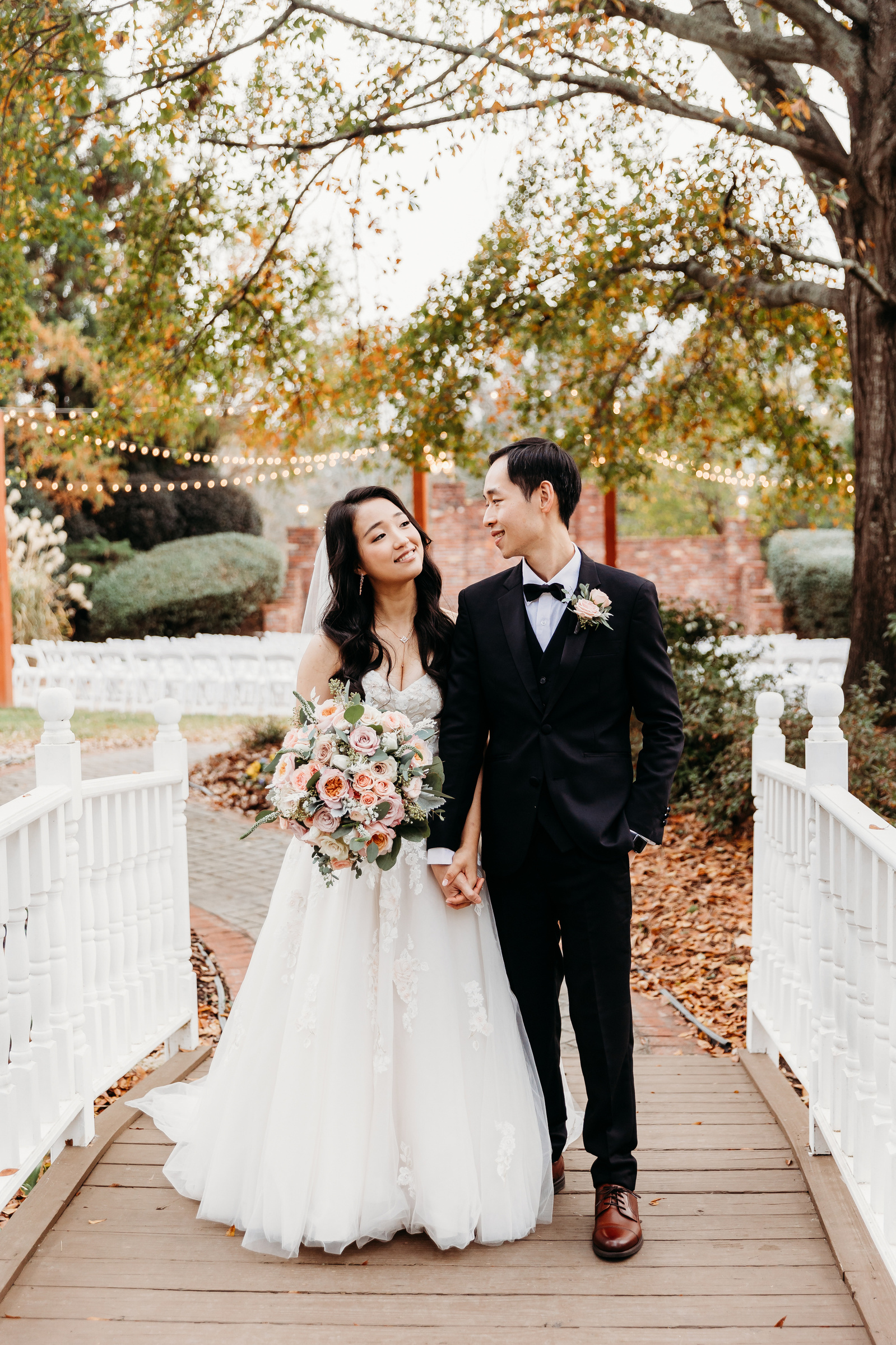 bride and groom on a white bridge, looking at each other