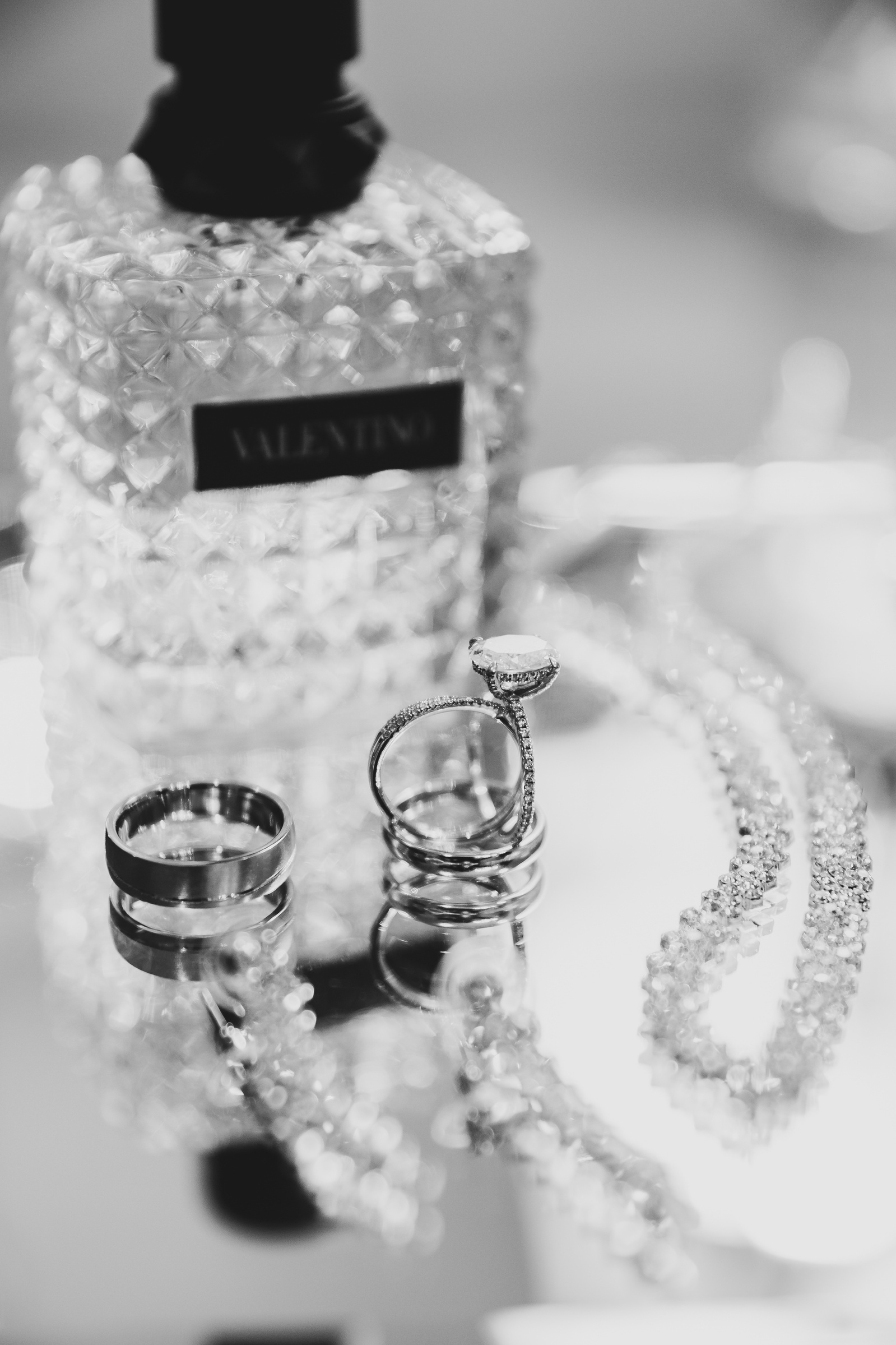 brides valentino perfume bottle on a mirror tray with the rings in the foreground