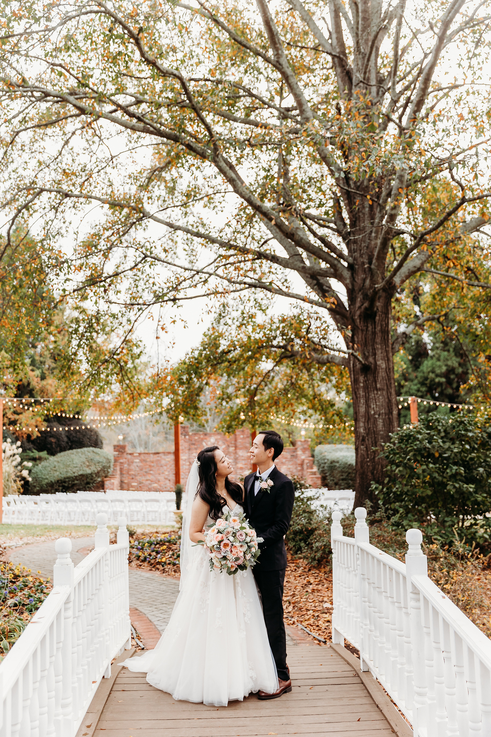 bride and groom on a white bridge, looking at each other