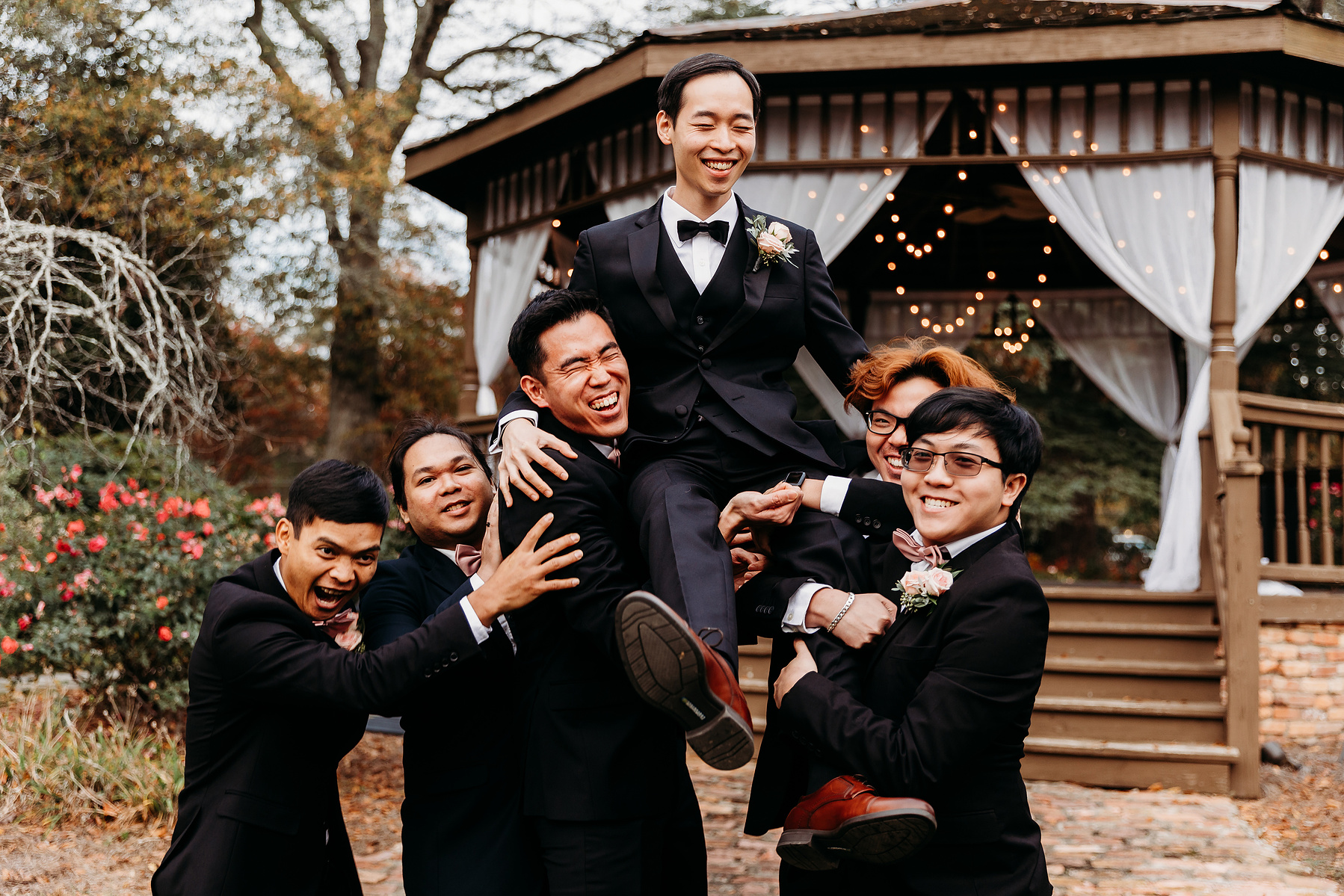 groomsmen lift groom to celebrate