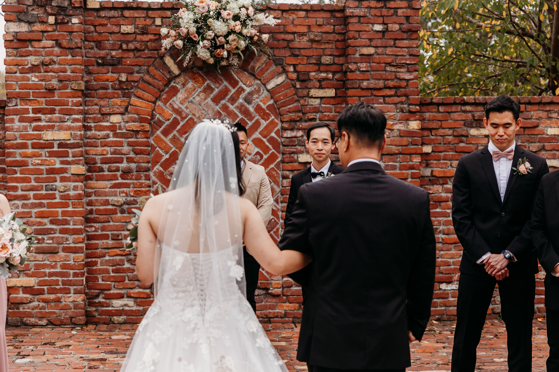 grooms reaction as bride walks down the aisle, shot from over the brides shoulder 
